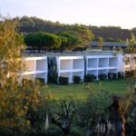 Nuno Graça Moura's 24 Row Houses at Bom Sucesso Resort showcasing a modern estate design with landscaped gardens, shaded areas, and villa-style architecture.