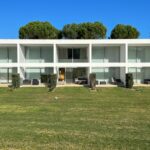 Nuno Graça Moura's 24 Row Houses at Bom Sucesso Resort showcasing a modern estate design with villa-like structures, landscaped surroundings, and balconies.