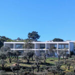 Nuno Graça Moura's 24 Row Houses at Bom Sucesso Resort showcasing modern architecture with a sleek glass façade, spacious balconies, and integrated landscaping.