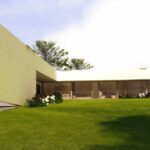 Nuno Graça Moura's 8 Villas at Bom Sucesso Resort showcasing modern architecture with a sleek design, featuring expansive glass façades, landscaped gardens, and spacious lawns.