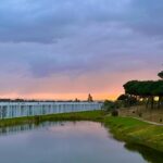 Nuno Graça Moura's Bar Code 1 - 30 Row Houses at Bom Sucesso Resort showcasing a modern design with a reflective watercourse and serene evening ambiance.