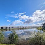 Nuno Graça Moura's Bar Code 1 - 30 Row Houses at Bom Sucesso Resort showcasing a modern design with a reflecting pool and watercourse elements integrated into the landscape.