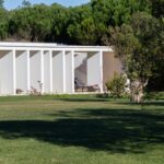 Nuno Graça Moura's Bar Code 2 - 12 Row Houses at Bom Sucesso Resort showcasing a modern design with composite material, concrete structures, and landscaped gardens with a well-maintained lawn.