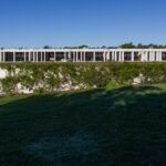 Nuno Graça Moura's Bar Code 2 - 12 Row Houses at Bom Sucesso Resort showcasing a modern design with a landscaped garden, shaded courtyards, and prominent columns enhancing daylighting.