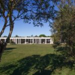 Nuno Graça Moura's Bar Code 2 - 12 Row Houses at Bom Sucesso Resort showcasing a modern design with a landscaped garden, expansive lawn, and surrounding trees.