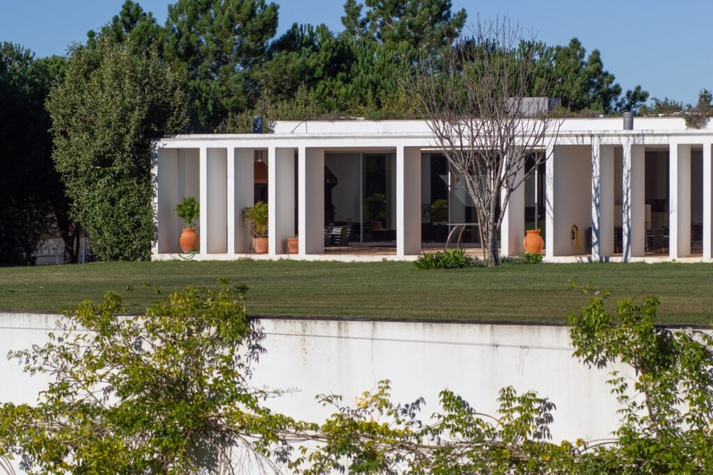 Nuno Graça Moura's Bar Code 2 - 12 Row Houses at Bom Sucesso Resort showcasing a plain land lot with landscaped gardens, shaded areas, and a well-maintained lawn.
