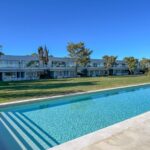 Nuno Graça Moura's Bar Code 2 - 12 Row Houses at Bom Sucesso Resort showcasing a modern villa design with a water feature, swimming pool, and eco-friendly landscaping.
