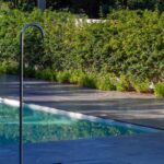 Nuno Graça Moura's Bar Code 2 - 12 Row Houses at Bom Sucesso Resort showcasing a modern design with a swimming pool, landscaped garden, and evergreen shrubs providing shade and privacy.