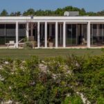 Nuno Graça Moura's Bar Code 2 - 12 Row Houses at Bom Sucesso Resort showcasing a modern design with a landscaped garden, outdoor structures, and ample daylighting.