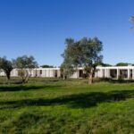 Nuno Graça Moura's Bar Code 2 - 12 Row Houses at Bom Sucesso Resort showcasing a plain land lot with landscaped gardens, shaded areas, and a well-maintained lawn.
