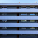 Adalberto Dias’s Casas Brancas, a high-rise condominium featuring a brutalist concrete and glass façade with cantilevered balconies and composite material accents, captured in daytime.