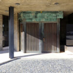 Agostinho Ricca’s Igreja do Foco / Igreja de Nossa Senhora da Boavista showcasing a concrete structure with composite material walls, a shaded entrance door, and modern flooring elements.