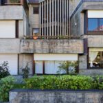Agostinho Ricca’s Igreja do Foco / Igreja de Nossa Senhora da Boavista showcasing a modern façade with clean lines, balcony elements, and a combination of siding materials in a residential area setting.