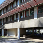 Alexandre Alves Costa and Sérgio Fernandez’s Escola de Ciências Sociais at Universidade do Minho showcasing a brutalist concrete structure with composite materials, featuring a shaded courtyard and urban design elements that emphasize daylighting and engineering.
