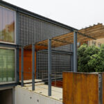 Casa Ferro by Alexandre Teixeira da Silva and Miguel Ribeiro de Sousa showcasing a modern façade with composite metal and iron materials, concrete walls, glass balconies, and strategic shading for daylighting.