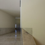 Álvaro Siza Vieira and Eduardo Souto de Moura’s Museum of International Contemporary Sculpture showcasing minimalist concrete walls, composite material flooring with tile patterns, and ample daylighting through large openings.
