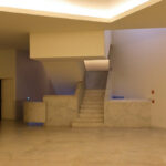 Museum of International Contemporary Sculpture designed by Álvaro Siza Vieira and Eduardo Souto de Moura featuring a spacious interior hall with concrete and plaster finishes, minimalist flooring, and ample daylighting through large openings.