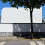 Álvaro Leite Siza Vieira Jr’s Casa Fez showcasing a minimalist concrete façade with plaster finishes, sharp shadows, and strategic daylighting highlighting the composite material walls.