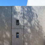 Álvaro Leite Siza Vieira Jr’s Casa Fez showcasing a grey concrete composite material façade with sharp daylighting shadows highlighting its minimalist wall structure.