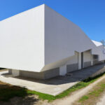 Álvaro Leite Siza Vieira Jr’s Casa Fez showcasing a brutalist architecture style with concrete and plaster surfaces, featuring sharp shadows and daylighting that emphasize its composite material structure and urban design elements.