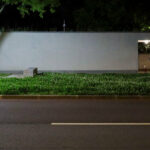 Álvaro Siza Vieira’s Abrigos da Linha de Metro-Bus “Boavista-Império” showcasing concrete public shelters with sharp shadows and shaded areas captured at night.
