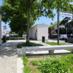Álvaro Siza Vieira’s Abrigos da Linha de Metro-Bus “Boavista-Império” showcasing concrete bus shelters integrated with landscaped public spaces, shaded walkways, and urban sidewalk design featuring plants and human activity.