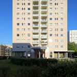 Álvaro Siza Vieira and António Madureira’s Edifício de Habitação da Boavista showcasing a high-rise residential building with a composite material façade, large windows, and modern urban design in a metropolitan condominium area during daytime.