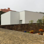 Álvaro Siza Vieira’s Casa Armanda Passos showcasing a minimalist concrete structure with plastered walls and composite material tiles.