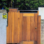 Álvaro Siza Vieira’s Casa Luís Rocha Ribeiro showcasing a brown stained hardwood exterior with vertical wooden planks and a minimalist wooden gate.