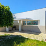 Álvaro Siza Vieira’s Centro Social e Paroquial de Sao Miguel de Ceide showcasing a minimalist concrete structure with composite material walls, shaded garden landscaping, and an integrated yard.