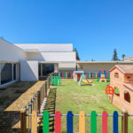 Álvaro Siza Vieira’s Centro Social e Paroquial de Sao Miguel de Ceide showcasing a modern kindergarten with a central courtyard, outdoor play equipment, and artificial turf.