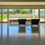 Álvaro Siza Vieira’s Centro de Estudos Camilianos interior showcasing wood-stained hardwood flooring, tiled ceiling, and a spacious lobby with modern tile flooring and refined interior design elements.
