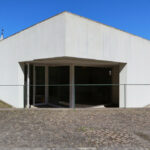 Álvaro Siza Vieira and Eduardo Souto de Moura’s Museum of International Contemporary Sculpture showcasing a minimalist concrete structure with plaster finishes, composite materials, prominent stairs, and ample daylighting.