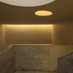 Álvaro Siza Vieira and Eduardo Souto de Moura’s Museum of International Contemporary Sculpture showcasing a minimalist interior with plaster ceilings, concrete composite flooring, and natural daylighting through large windows.