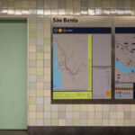 Álvaro Siza Vieira’s Estação de Metro São Bento showcasing a modern underground metro station interior with digital display devices, detailed transit maps, and architectural plans integrated into the design.