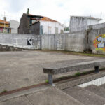 Álvaro Siza Vieira’s Habitação Social Bairro São Víctor - SAAL showcasing a concrete and composite material structure with grey walls, sloped stairs, and graffiti-painted surfaces.