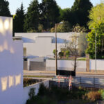 Álvaro Siza Vieira’s Moradias na Avenida da Boavista showcasing a residential complex with concrete walls, composite materials, home fencing, and urban design elements emphasizing daylighting and shadow.