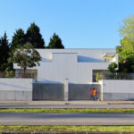 Álvaro Siza Vieira’s Moradias na Avenida da Boavista showcasing a residential area with concrete walls, composite materials, home fencing, and urban design elements in a suburban setting.