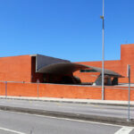 Álvaro Siza Vieira’s Pavilhão Multiusos de Gondomar showcasing a brutalist architecture style with composite materials, extensive brickwork, and large shaded daylighting elements.