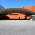 Álvaro Siza Vieira’s Pavilhão Multiusos de Gondomar showcasing a concrete and steel structure with composite material flooring, featuring large shaded areas and daylighting elements.