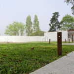 Álvaro Siza Vieira’s Piscina da Quinta da Conceição showcasing a minimalist concrete structure integrated with landscaped grass and garden areas, featuring shaded outdoor spaces and a composite material pool deck.