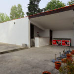 Álvaro Siza Vieira’s Piscina da Quinta da Conceição showcasing minimalist concrete walls, plaster finishes, and a shaded driveway emphasizing daylighting and composite materials.