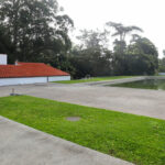 Álvaro Siza Vieira’s Piscina da Quinta da Conceição showcasing a minimalist concrete structure with integrated landscaping, artificial turf, and shaded garden areas within a spacious land lot.