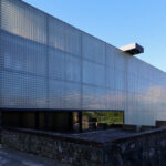 Casa Sacerdotal de São Martinho de Dume by André and António Fontes showcasing a composite material façade with metal structural elements and extensive daylighting features.