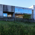 Projecto Homem by André and António Fontes showcasing a brutalist concrete structure with composite materials, featuring large daylighting openings and exposed engineering elements.