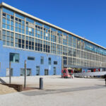 Carlos Prata and Manuel de Solà-Morales’ Edificio Transparente showcasing a daytime urban commercial building with a composite material façade, cantilevered shade structures, and a modern corporate headquarters design within a campus setting.