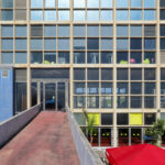 Carlos Prata and Manuel de Solà-Morales’ Edificio Transparente, a high-rise mixed-use commercial building featuring a composite material façade with extensive glass panels and modern urban design elements in a metropolitan area.