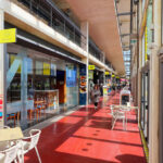 Carlos Prata and Manuel de Solà-Morales' Edificio Transparente showcasing a modern steel and aluminium structure with a transparent glass façade and integrated bicycle parking featuring multiple bicycles and bicycle equipment.