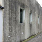 EZZO’s Casa de Leça showcasing a brutalist architecture style with grey concrete and composite material walls, featuring textured cement and plaster surfaces that emphasize daylighting.