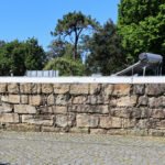 Eduardo Souto de Moura’s Casa 1 em Miramar showcasing a stone and limestone exterior with textured cobblestone and rubble walls forming a robust, natural façade.